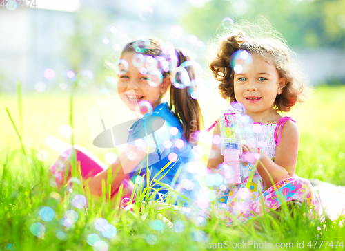 Image of Two little girls are blowing soap bubbles