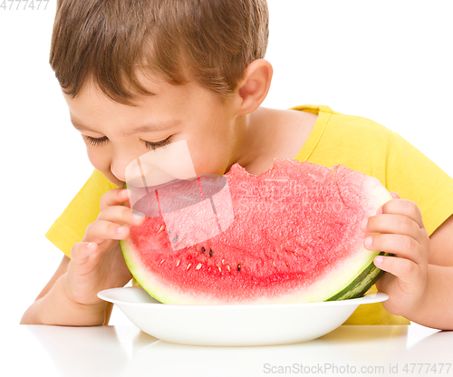 Image of Little boy is eating watermelon
