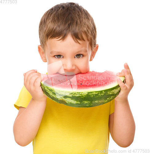 Image of Little boy is eating watermelon