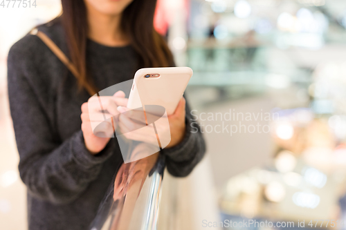 Image of Woman use of cellphone in shopping mall