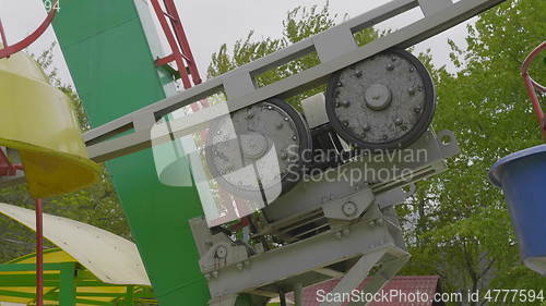 Image of Underside view of a ferris wheel over blue sky.