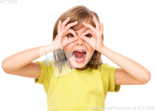 Image of Happy little girl is showing glasses gesture
