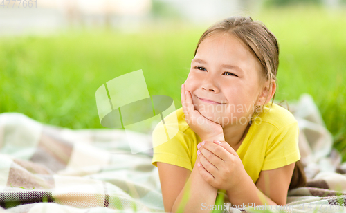 Image of Portrait of a little girl laying on green grass