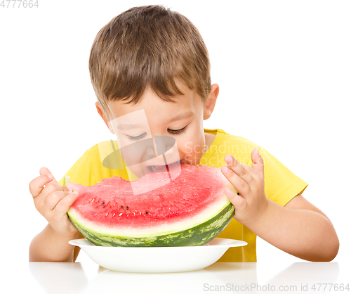 Image of Little boy is eating watermelon