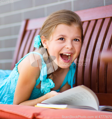 Image of Little girl is reading a book