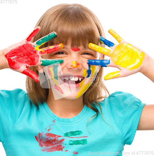 Image of Portrait of a cute girl playing with paints