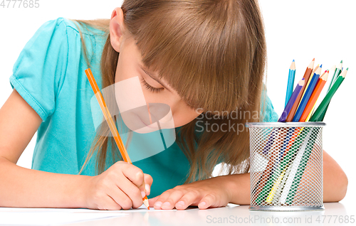 Image of Little girl is drawing using pencils