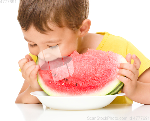 Image of Little boy is eating watermelon