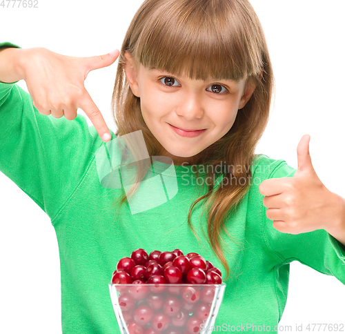 Image of Cute girl is eating cherries showing thumb up sigh