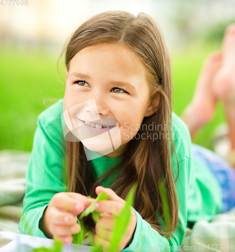 Image of Portrait of a little girl laying on green grass