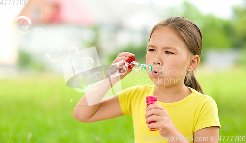 Image of Little girl is blowing a soap bubbles