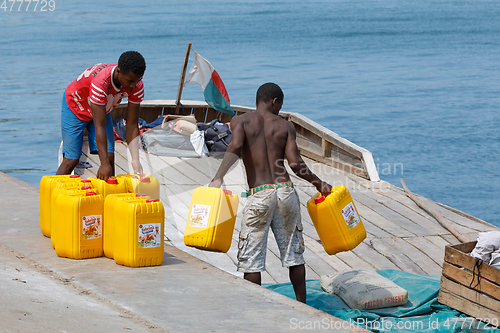 Image of Malagasy men transport cargo from ship in port of Nosy Be, Madag