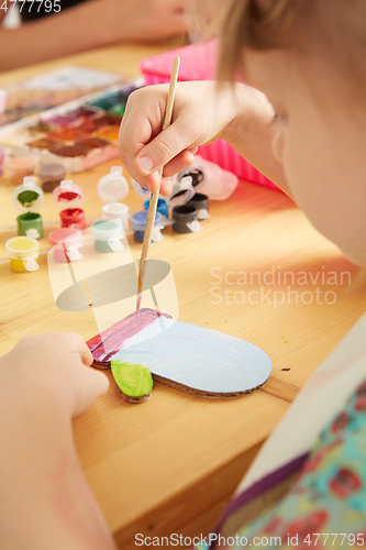 Image of Cute little girl painting on home interior background