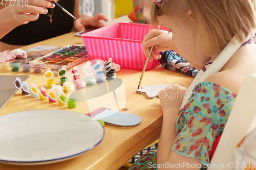 Image of Cute little girl painting on home interior background
