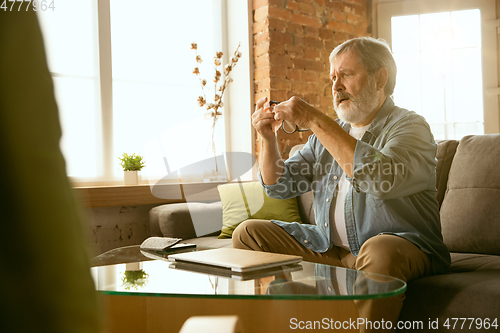 Image of Senior man working with laptop at home - concept of home studying