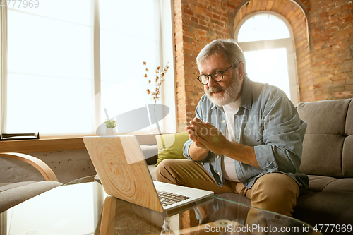 Image of Senior man working with laptop at home - concept of home studying