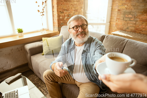 Image of Senior man working with laptop at home - concept of home studying