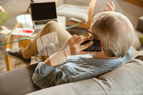 Image of Senior man working with laptop at home - concept of home studying