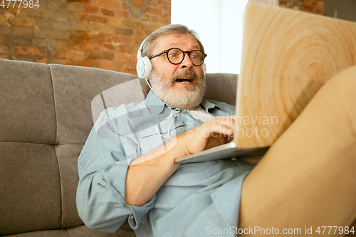 Image of Senior man working with laptop at home - concept of home studying