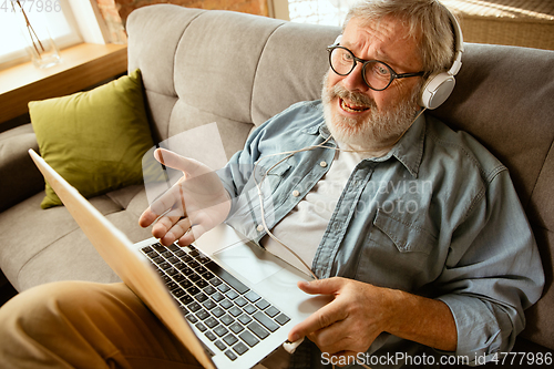 Image of Senior man working with laptop at home - concept of home studying