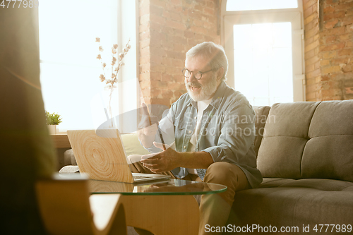 Image of Senior man working with laptop at home - concept of home studying