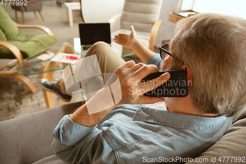 Image of Senior man working with laptop at home - concept of home studying