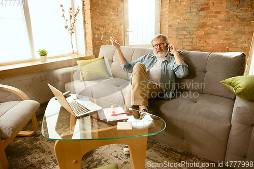 Image of Senior man working with laptop at home - concept of home studying