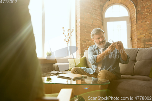 Image of Senior man working with laptop at home - concept of home studying