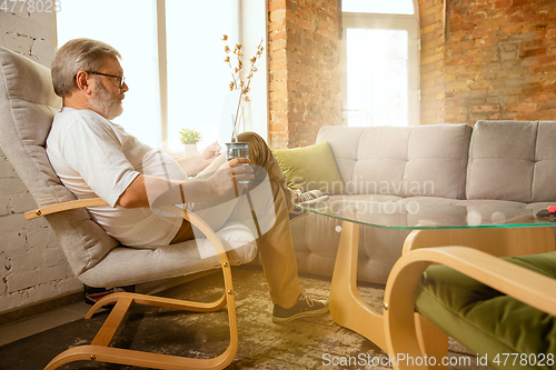 Image of Senior man working with tablet at home - concept of home studying