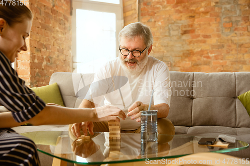 Image of Senior man doing his wooden constructor at home - concept of home studying