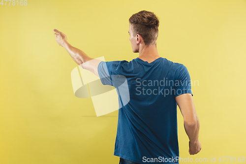 Image of Caucasian young man\'s half-length portrait on yellow background
