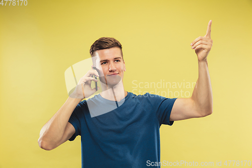 Image of Caucasian young man\'s half-length portrait on yellow background