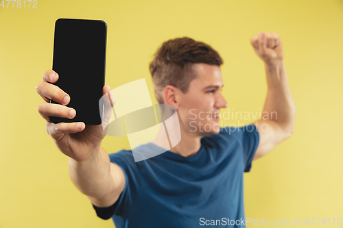 Image of Caucasian young man\'s half-length portrait on yellow background