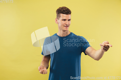 Image of Caucasian young man\'s half-length portrait on yellow background