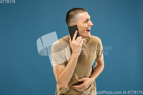 Image of Caucasian young man\'s half-length portrait on blue background