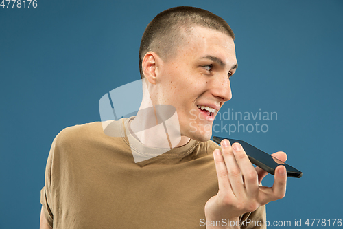 Image of Caucasian young man\'s half-length portrait on blue background