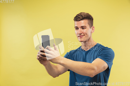 Image of Caucasian young man\'s half-length portrait on yellow background
