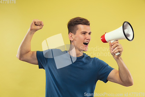 Image of Caucasian young man\'s half-length portrait on yellow background