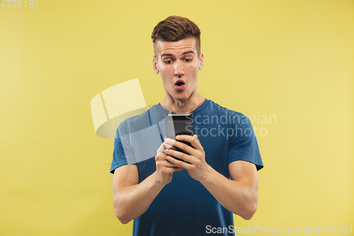 Image of Caucasian young man\'s half-length portrait on yellow background