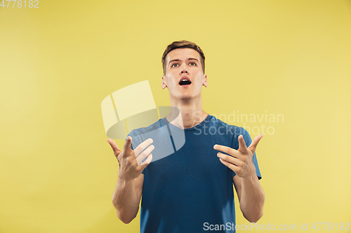 Image of Caucasian young man\'s half-length portrait on yellow background