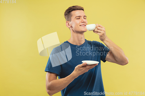 Image of Caucasian young man\'s half-length portrait on yellow background