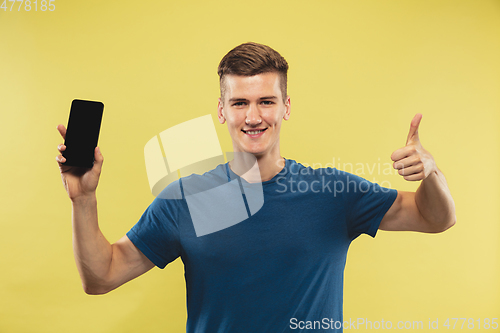 Image of Caucasian young man\'s half-length portrait on yellow background