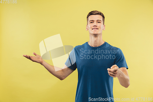 Image of Caucasian young man\'s half-length portrait on yellow background