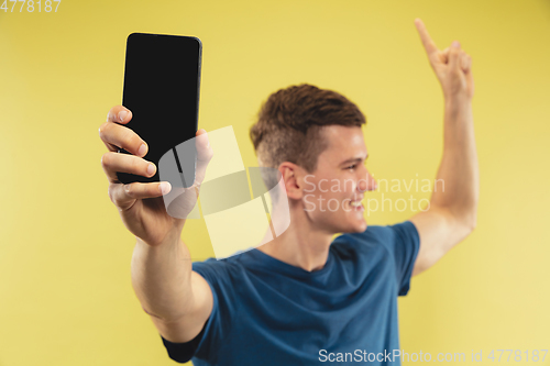 Image of Caucasian young man\'s half-length portrait on yellow background