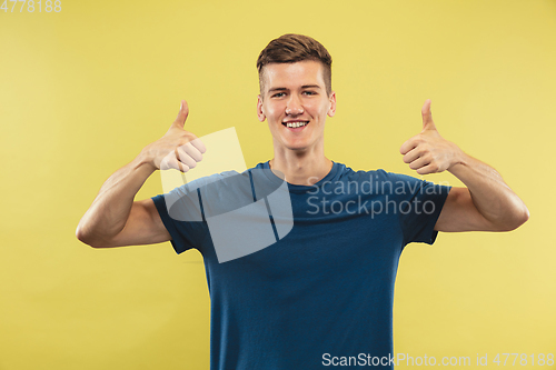 Image of Caucasian young man\'s half-length portrait on yellow background