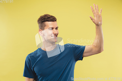 Image of Caucasian young man\'s half-length portrait on yellow background