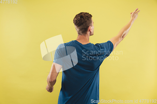 Image of Caucasian young man\'s half-length portrait on yellow background