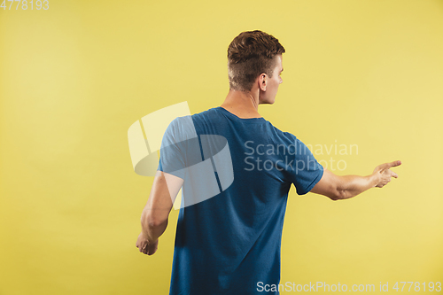 Image of Caucasian young man\'s half-length portrait on yellow background