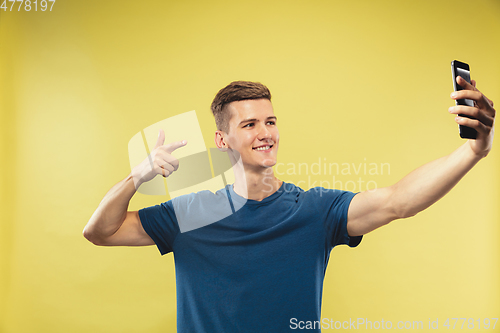 Image of Caucasian young man\'s half-length portrait on yellow background