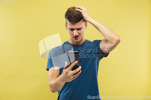 Image of Caucasian young man\'s half-length portrait on yellow background